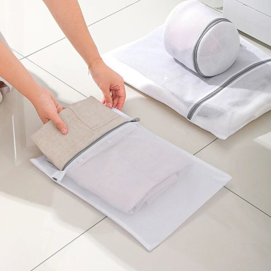 A person is keeping cloth to 4 Pcs Mesh Laundry Washing Bags Set.