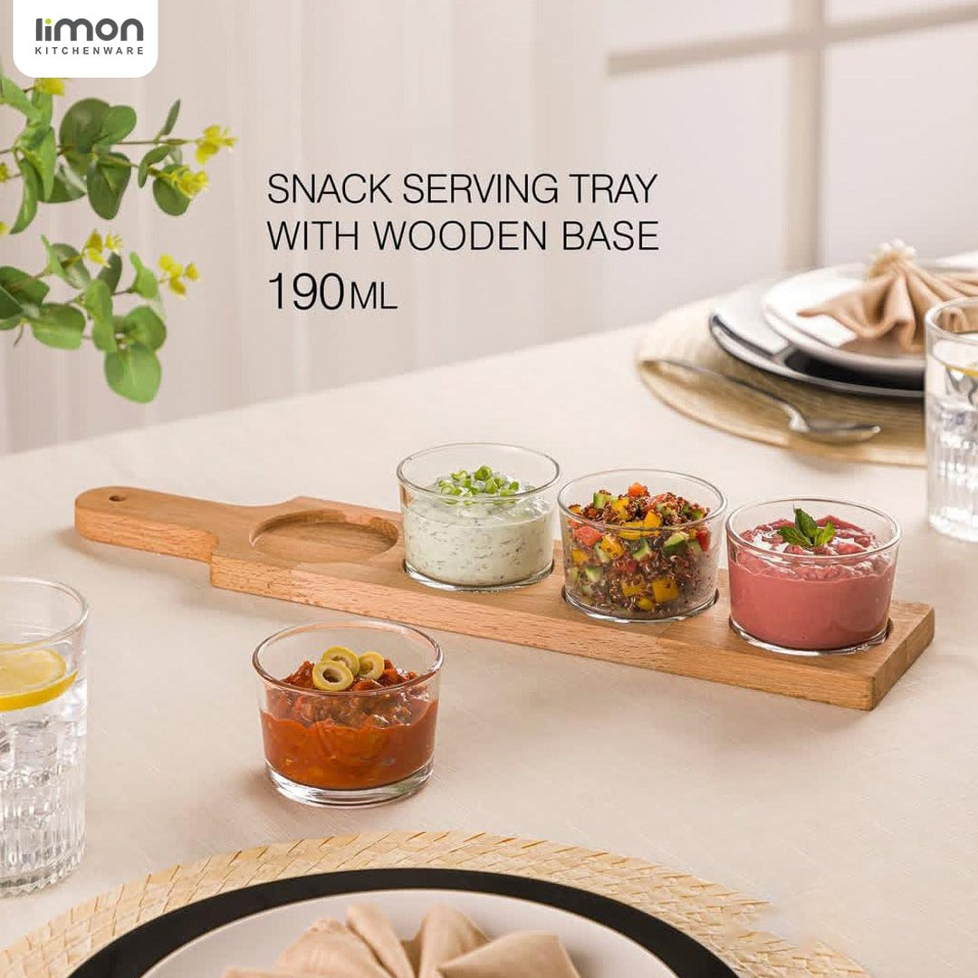A 4-section glass bowl serving platter with different food items.