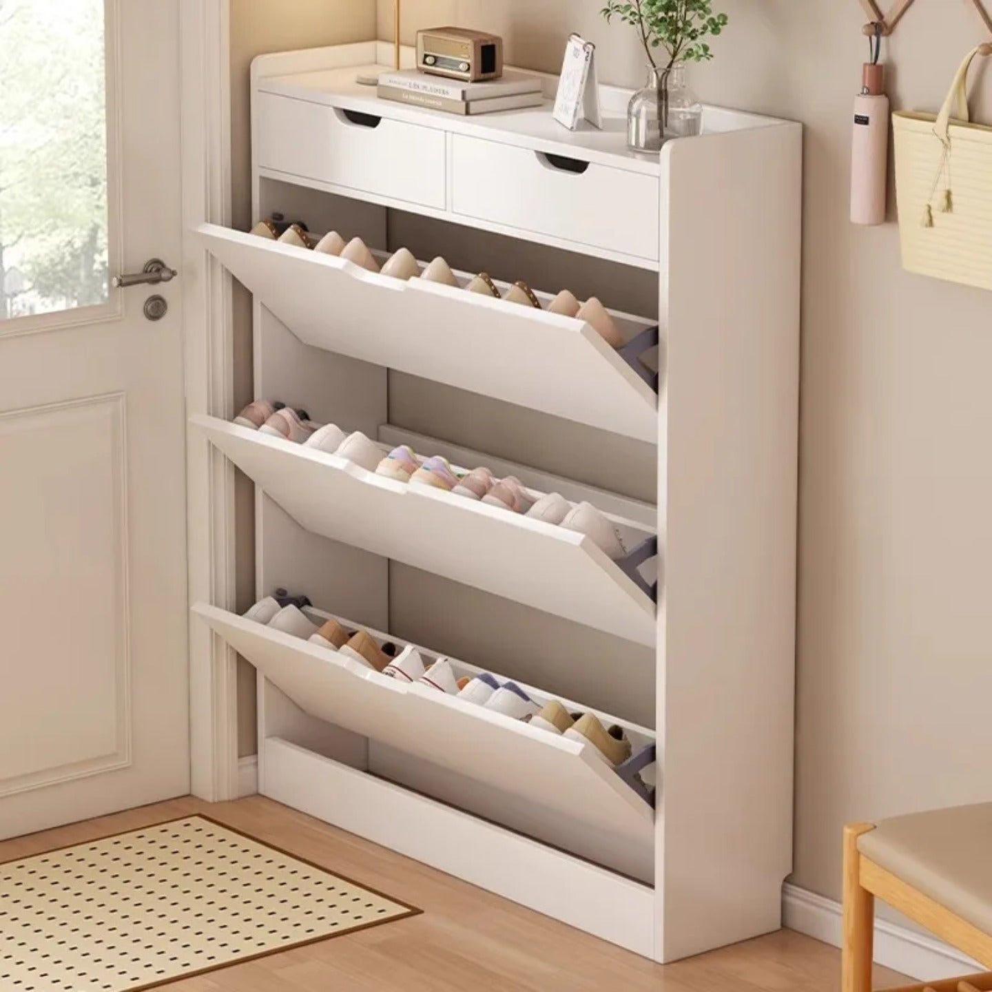 A slim shoe cabinet with flip drawers that neatly stores shoes while saving space, with a top surface for décor or essentials.