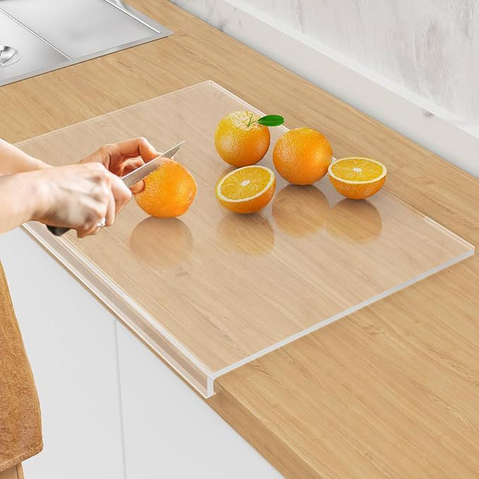 A Person is Cutting Fruits On an Acrylic Cutting Board.