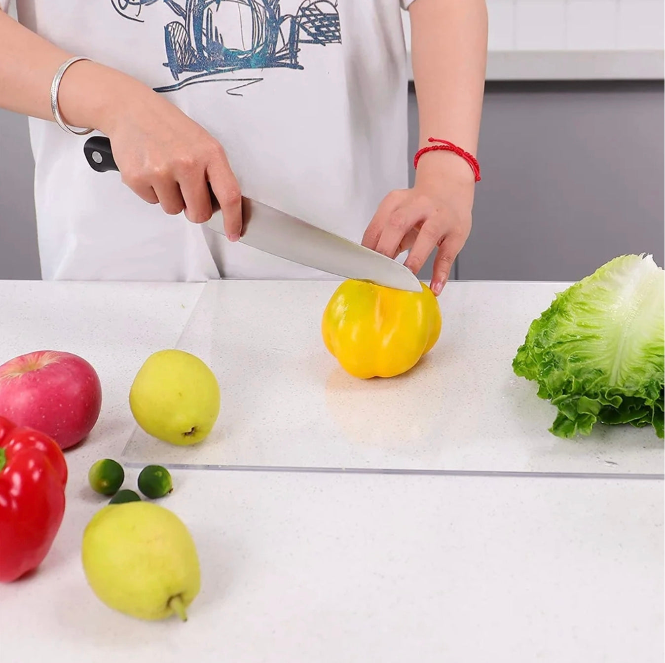 A Person is Cutting Vegetebles On an Acrylic Cutting Board.