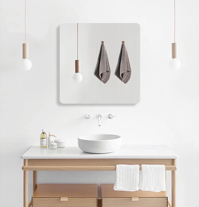 HD Self-Adhesive Acrylic Mirror Tiles placed on a wall in front of a table with a plate on