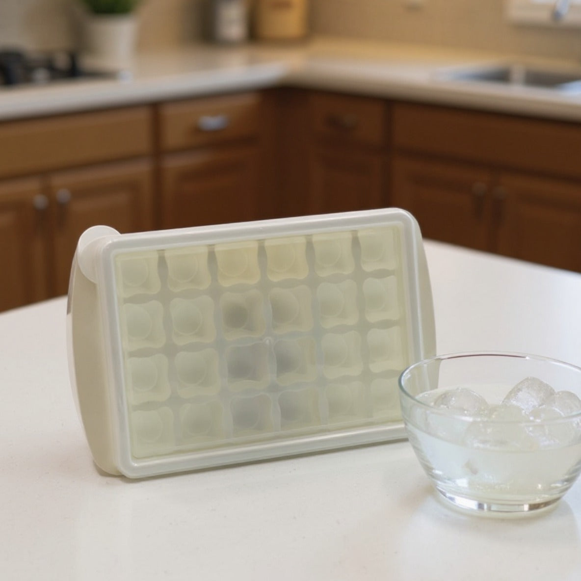 An Ice Cube Tray is Placed on a Kitchen Cabinet Along with a Bowl of Ice Cubes.