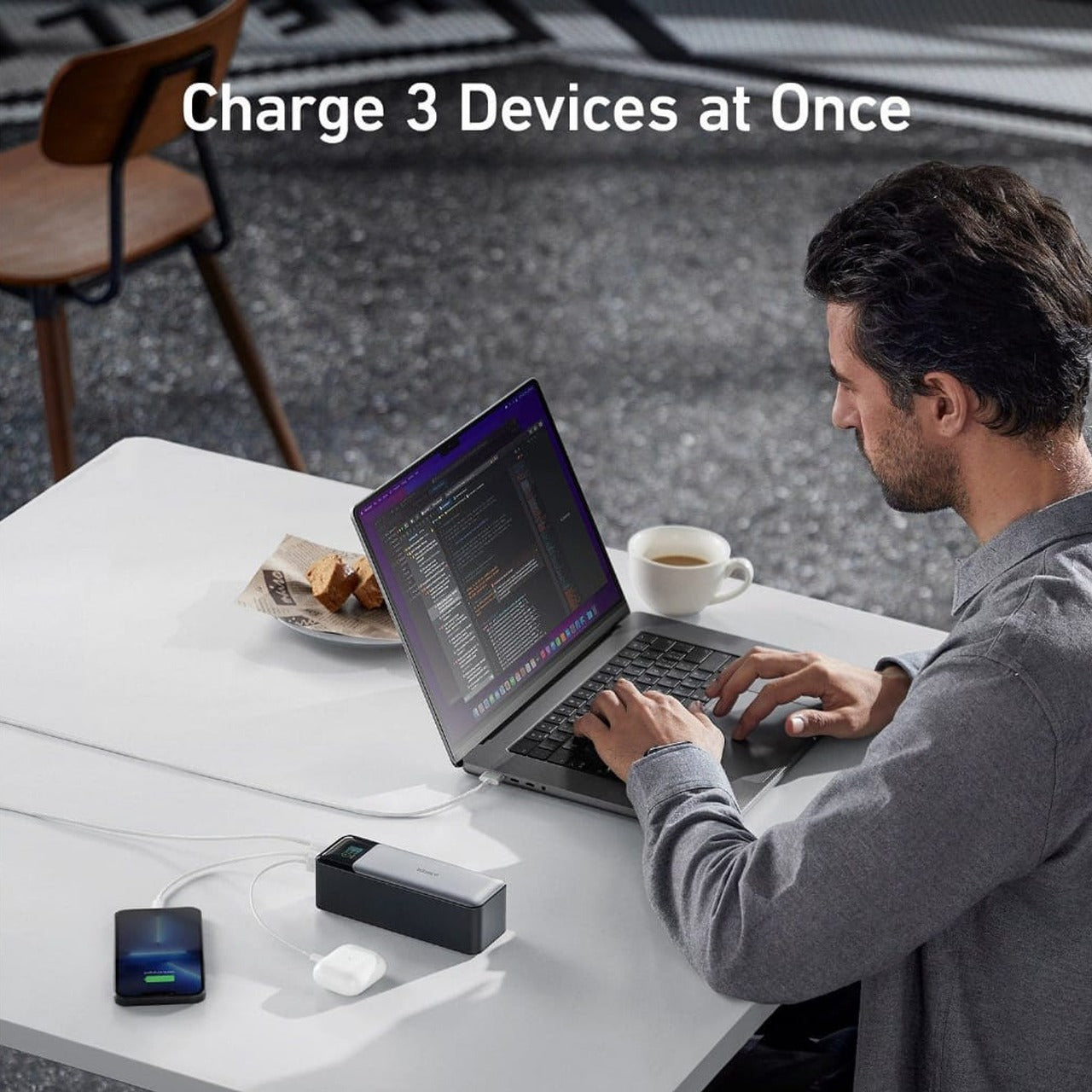 A Person is Using Laptop and Charging Mobile Phone, Airpod Using ANKER 737 Power Bank.
