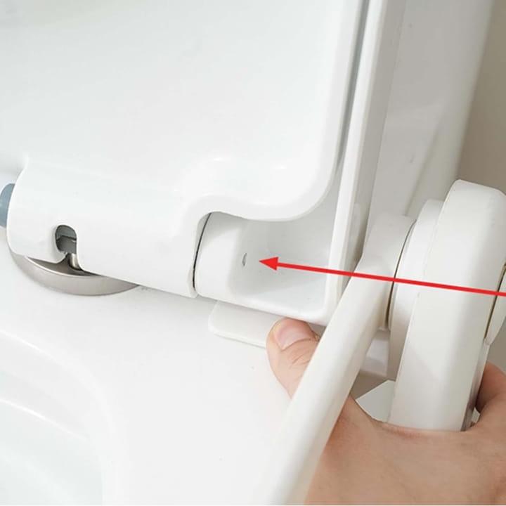 A Person is Attaching Pedal Type Toilet Lid Lifter to the Toilet.