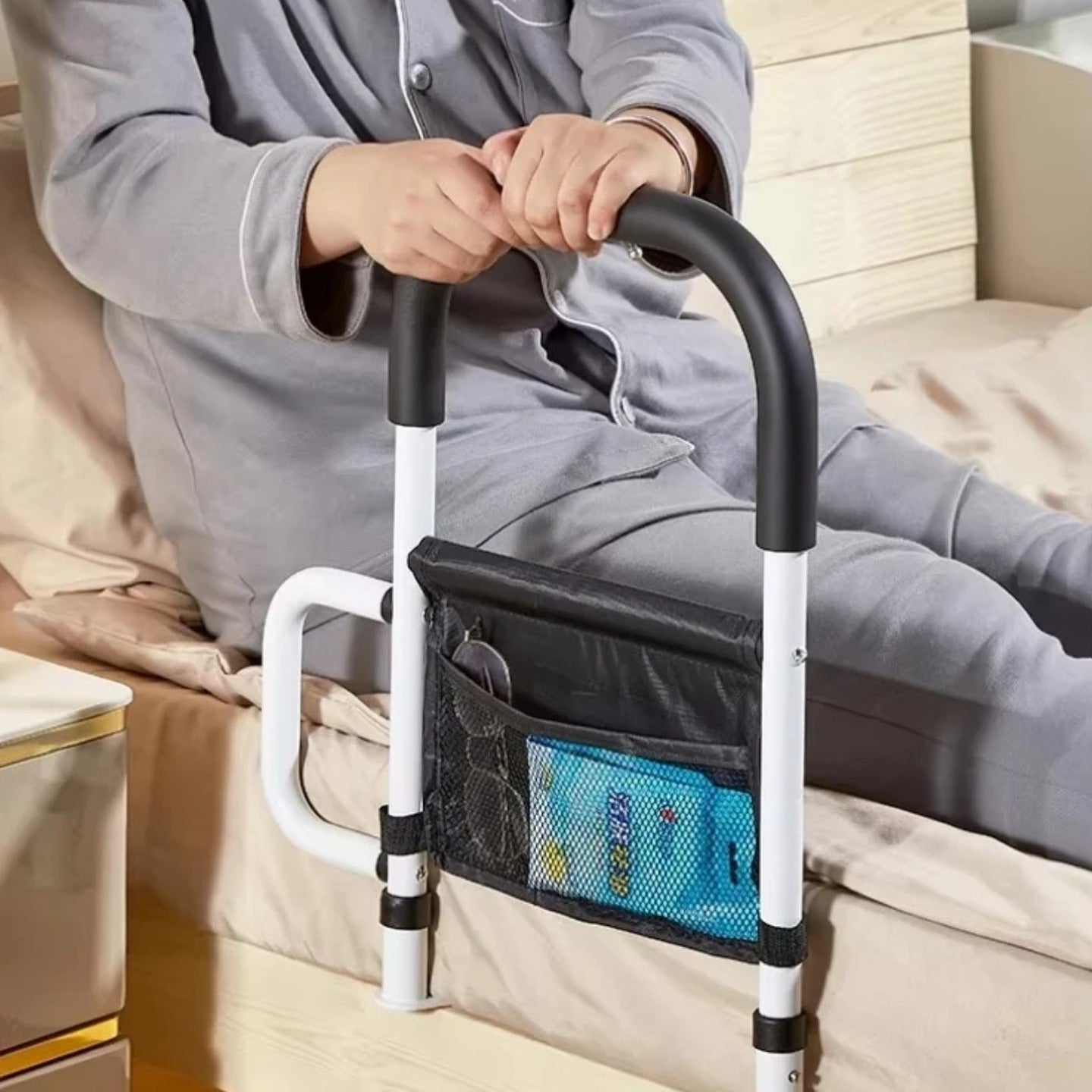 A Person is Sitting on the Bed with the support of Bed Assist Rail with Safety Handle.