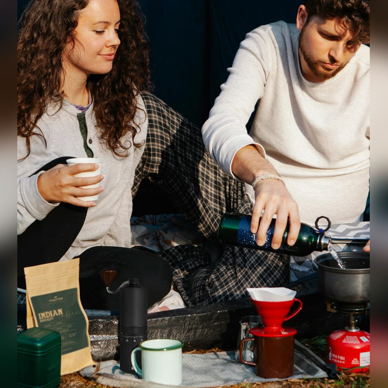 A Men and Women is Making Coffee Using Macnoa MacGrind Craft - Manual Hand Coffee Bean Grinder.