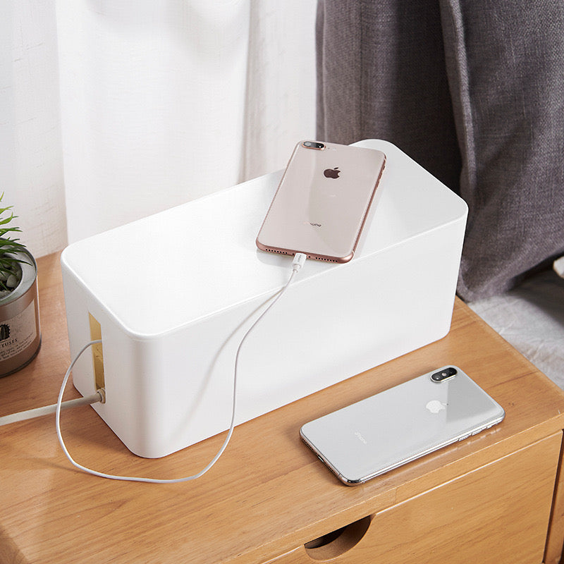 A Charging Iphone is Placed On Cable Organizer Box.