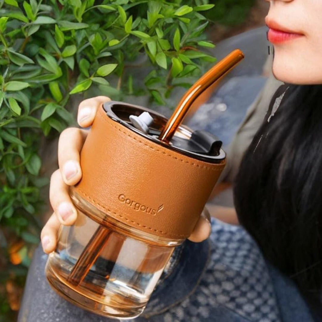 A Woman is drinking from Bamboo Glass Cup.