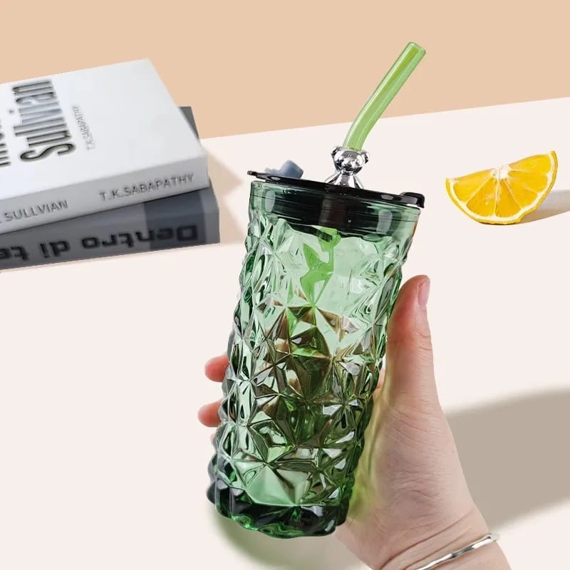 A Person is Holding Drinking Glass Tumbler With Straw and Lid.