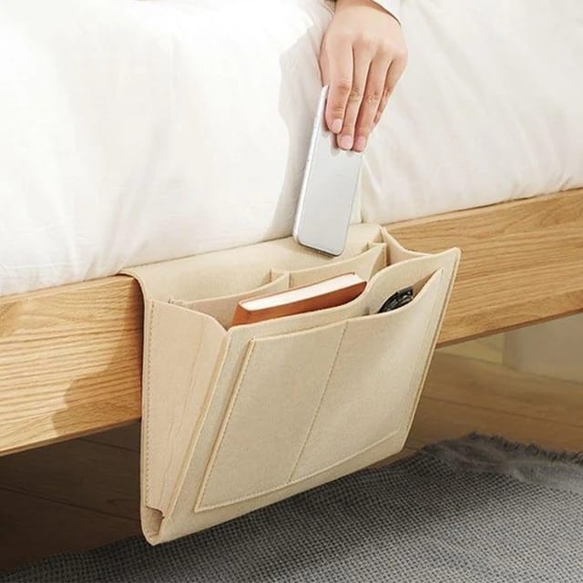 Someone taking a phone from the Felt Bedside Storage Bag