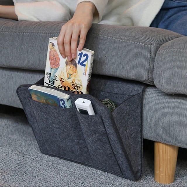 Someone taking a book from the Felt Bedside Storage Bag