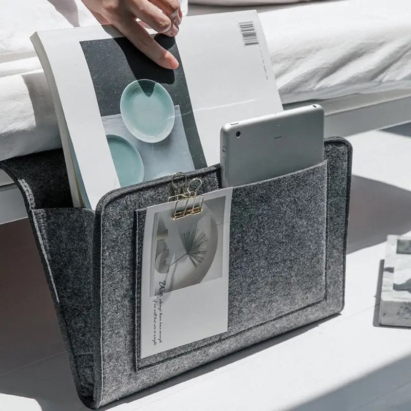 Someone taking a book from the Felt Bedside Storage Bag