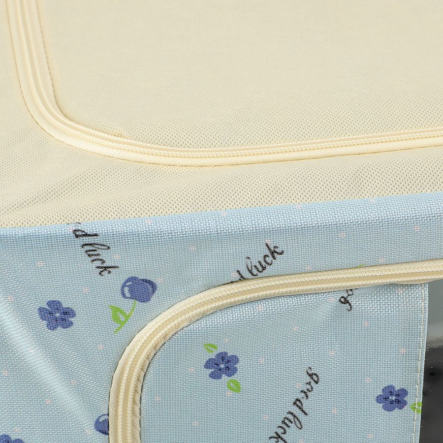 Close-up of a fabric Foldable Cloth Storage Organizer Box with a cream-colored mesh upper section and a light blue lower section printed with small blueberry motifs and script text.