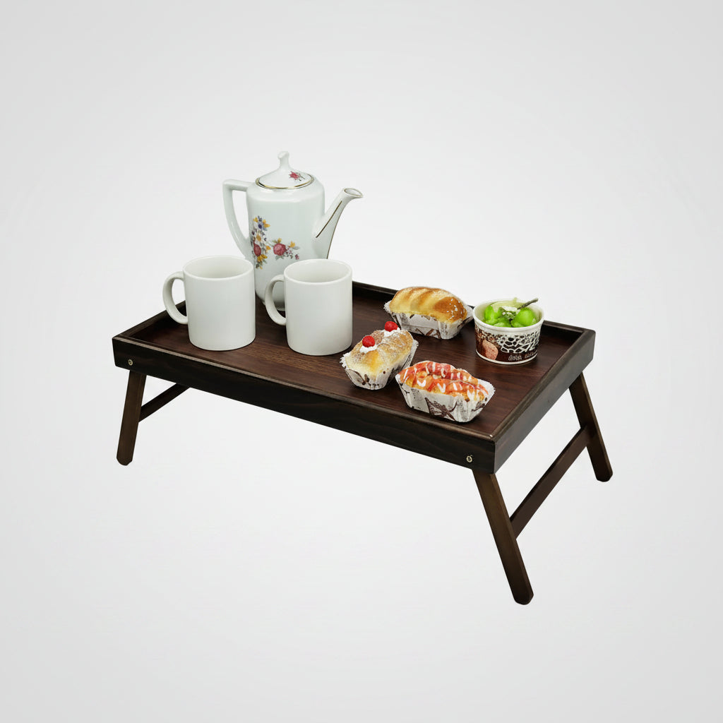 Foldable Wooden Bed Tray Table with breakfast items including a teapot, mugs, pastries, and a bowl on a light gray background.