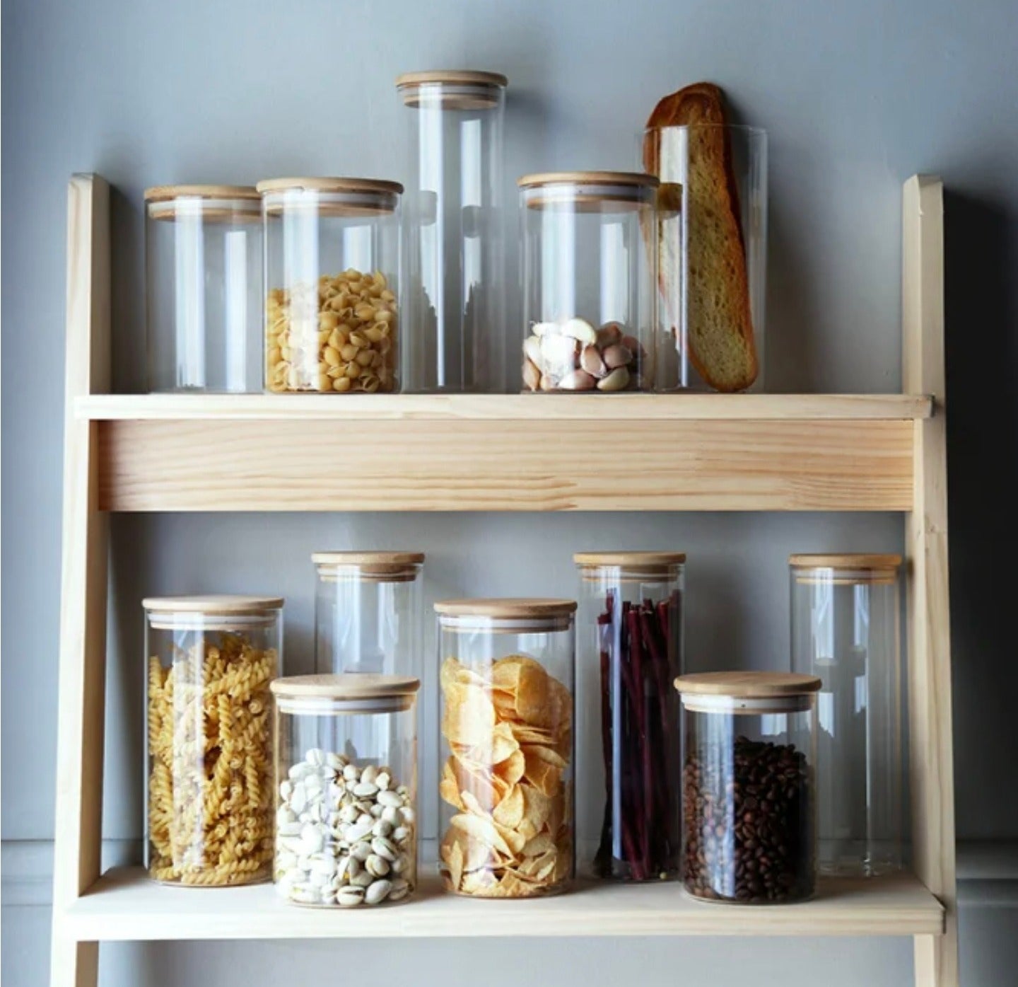 Glass Storage Jars Organized with Snacks and Spices are Kept on a Rack.