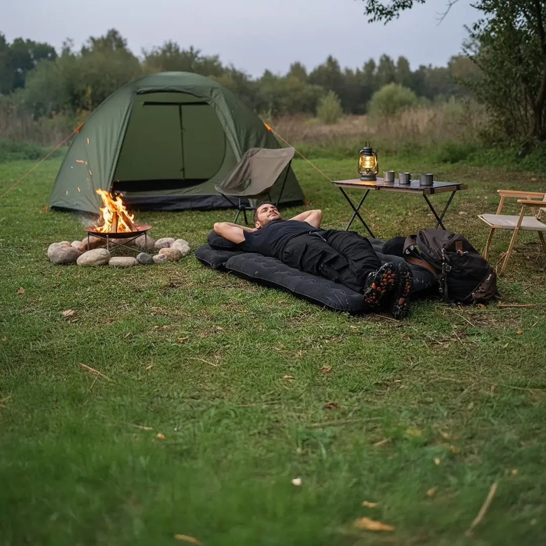 A Man is lying on Green Lion Inflatable Car Air Mattress While Camping.