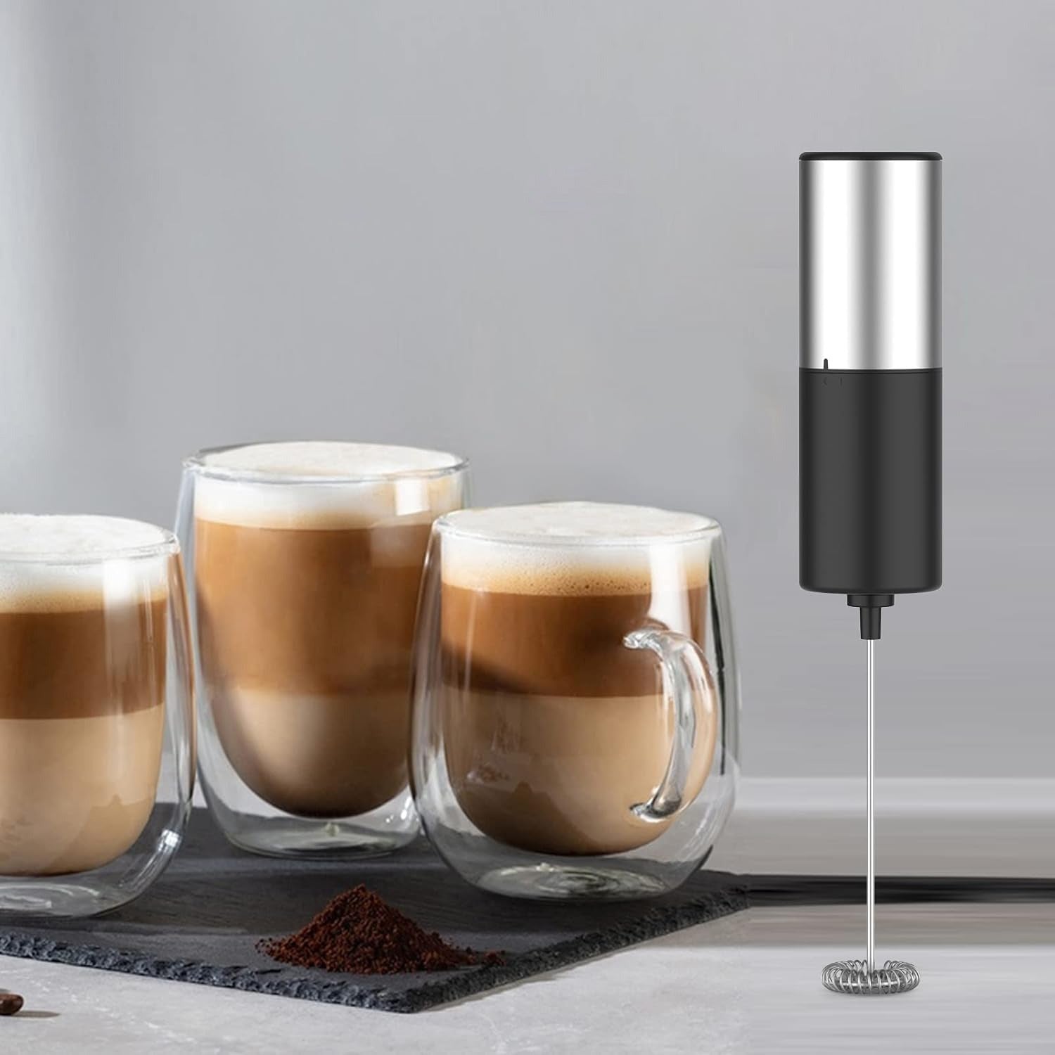 A Handheld Electric Milk Frother Placed Along with Coffee.