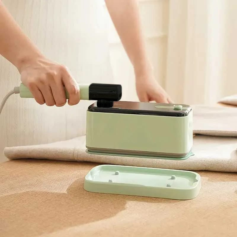A Person is Ironing Garment Using Handheld Travel Garment Iron Steamer.