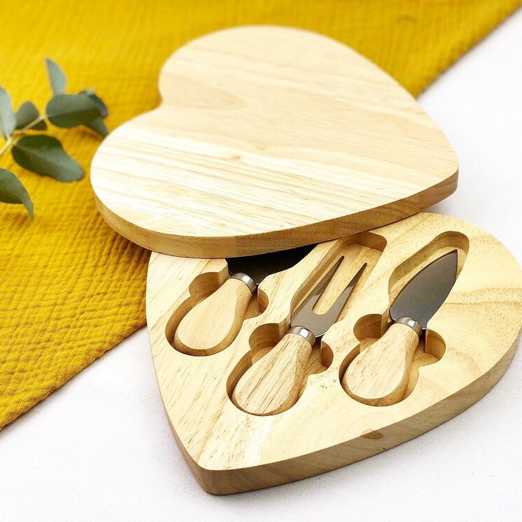 Heart-shaped wooden cheese board with built-in knife storage and serving area.