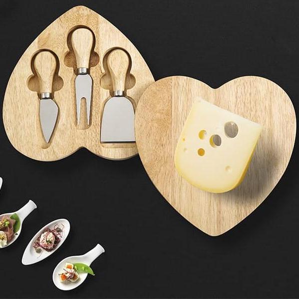 Heart-shaped wooden cheese board with built-in knife storage and served cheese.