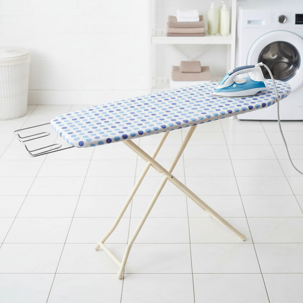 Heavy-duty folding ironing board with iron and clothes set up in a laundry area.