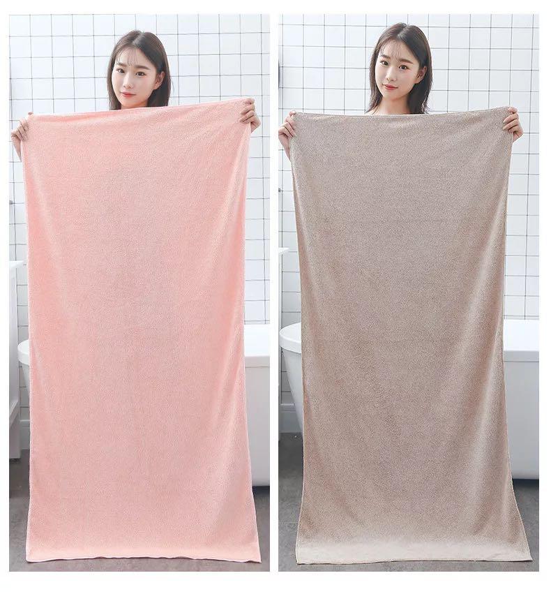 A lady showing a bath towel set for kids and adults