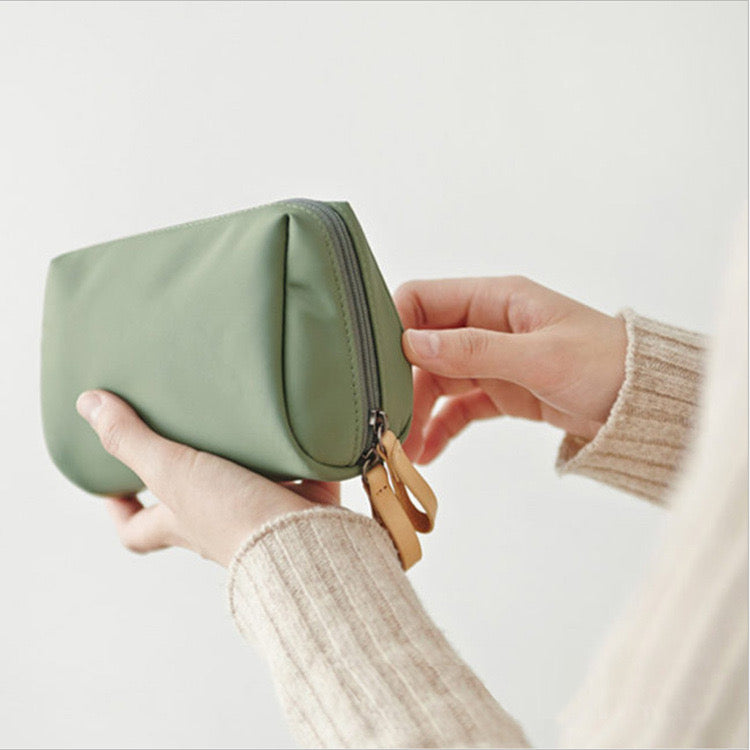 A lady is holding a Portable Waterproof Solid Color Cosmetic Bag Toiletry Storage Pouch