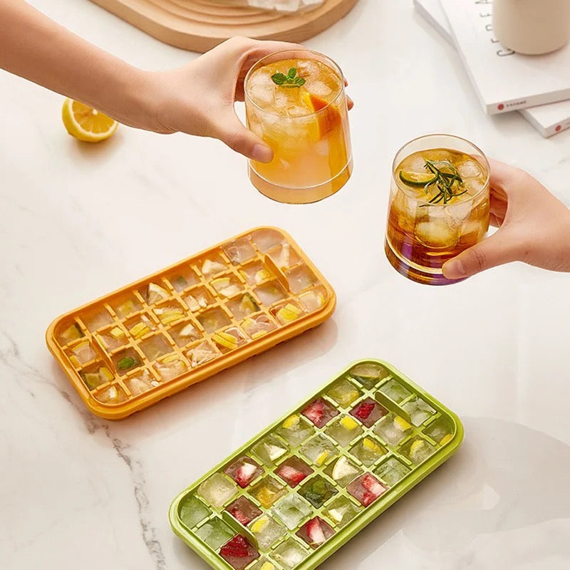 Two people holding beverages and a tray of ice cubes made with the One-Press Transparent Ice Making Mold