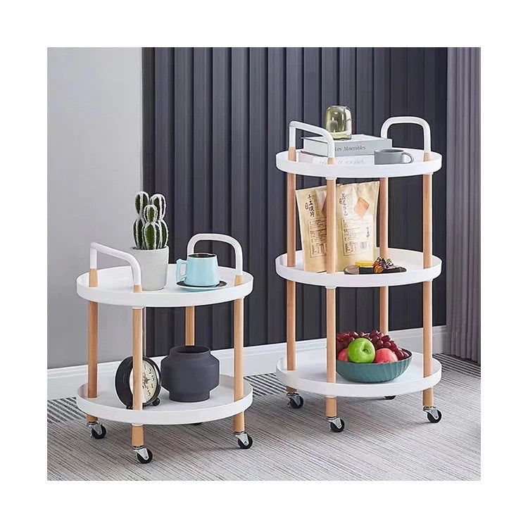 Multi-tier mobile storage table placed on the floor in front of the wall arranged with food