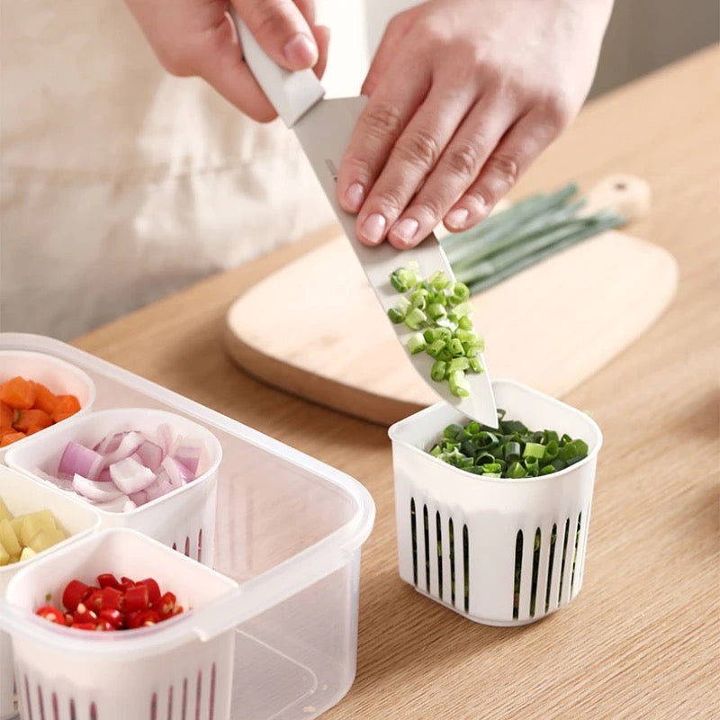A person neatly slices vegetables into small containers, using a 6-Grids Useful Refrigerator Food Fresh-keeping Storage Box