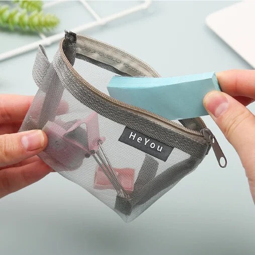A person holding a Mini Zipper Pouch mesh bag, with a paper inside