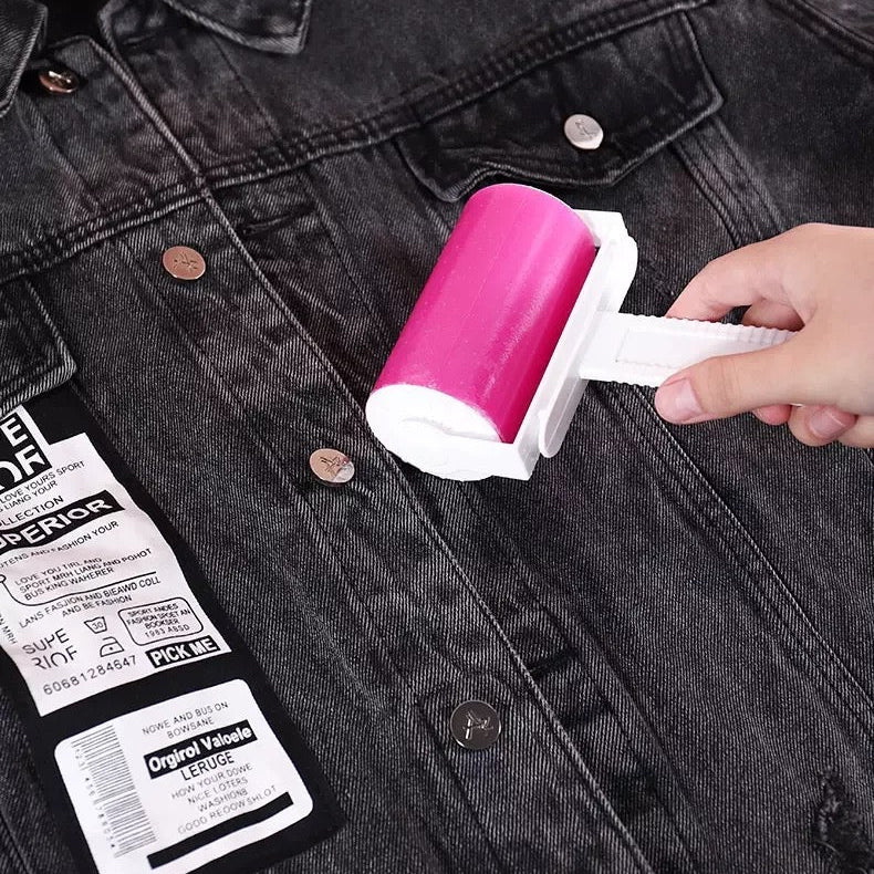 a hand rolling a pink Reusable Lint Remover on a denim jacket