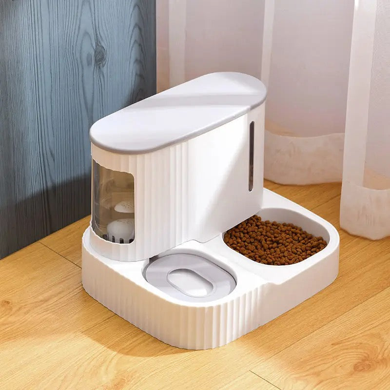 Grey color Automatic Pet Feeder & Water Dispenser placed on a wooden floor close to a wooden wall and curtain
