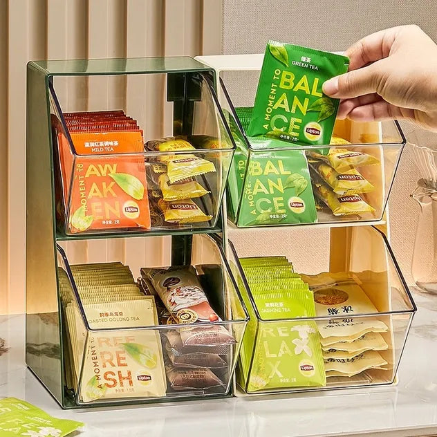 A hand taking packet of tea bag from a multi-layer desktop dustproof storage rack