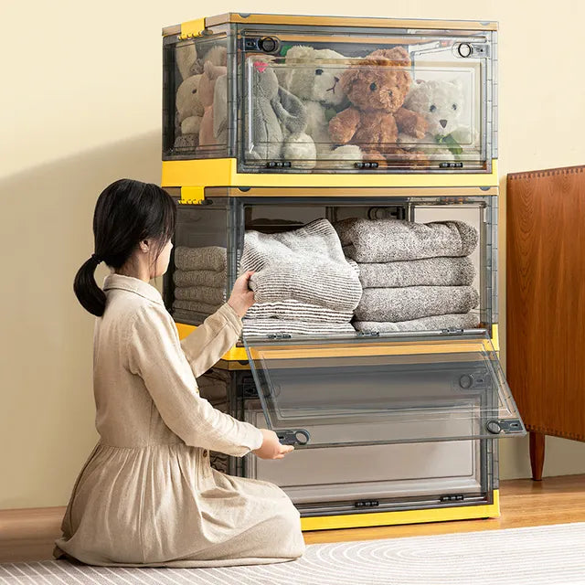 A woman sits beside a stackable plastic storage boxes