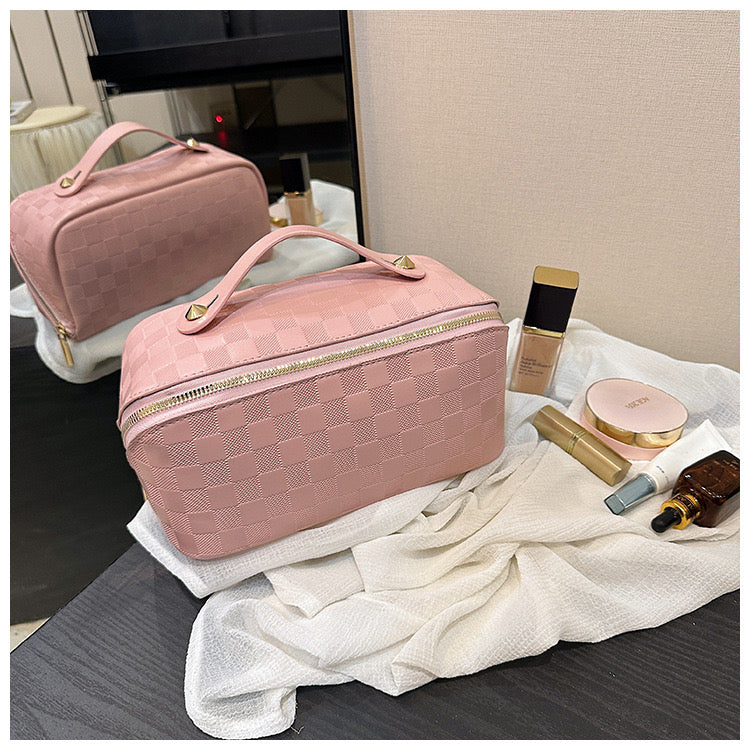 Pink color Cosmetic Bag kept next to cosmetic items on a table