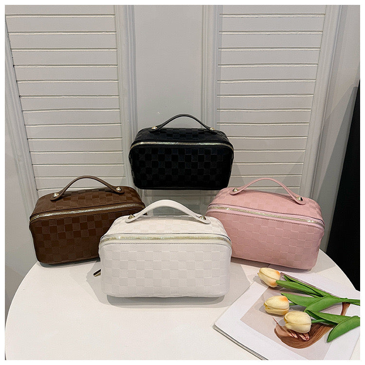 Cosmetic Bag placed next to a magazine and flowers on a table to showcase all the color variants