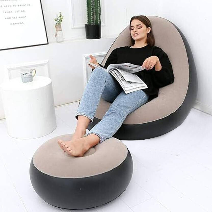 A woman is Resting on a Inflatable Sofa Chair with Foot Stool.