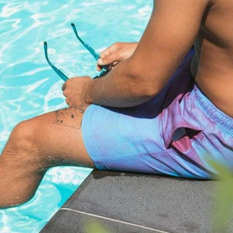 A Person is Wearing Men Color Changing Beach Shorts in Pool.
