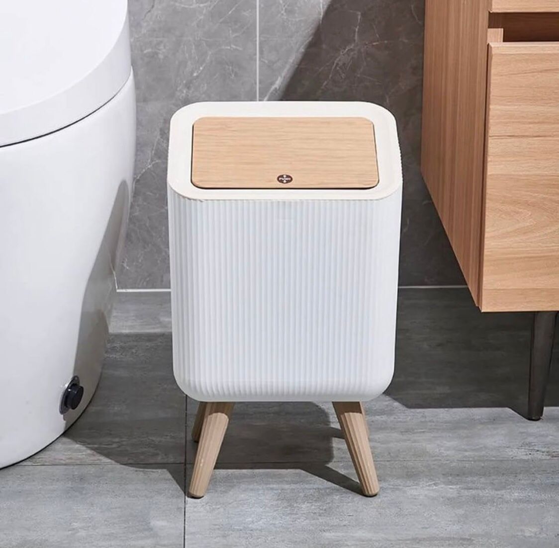 Modern Push Top Trash Can with Lid Placed at Bathroom.