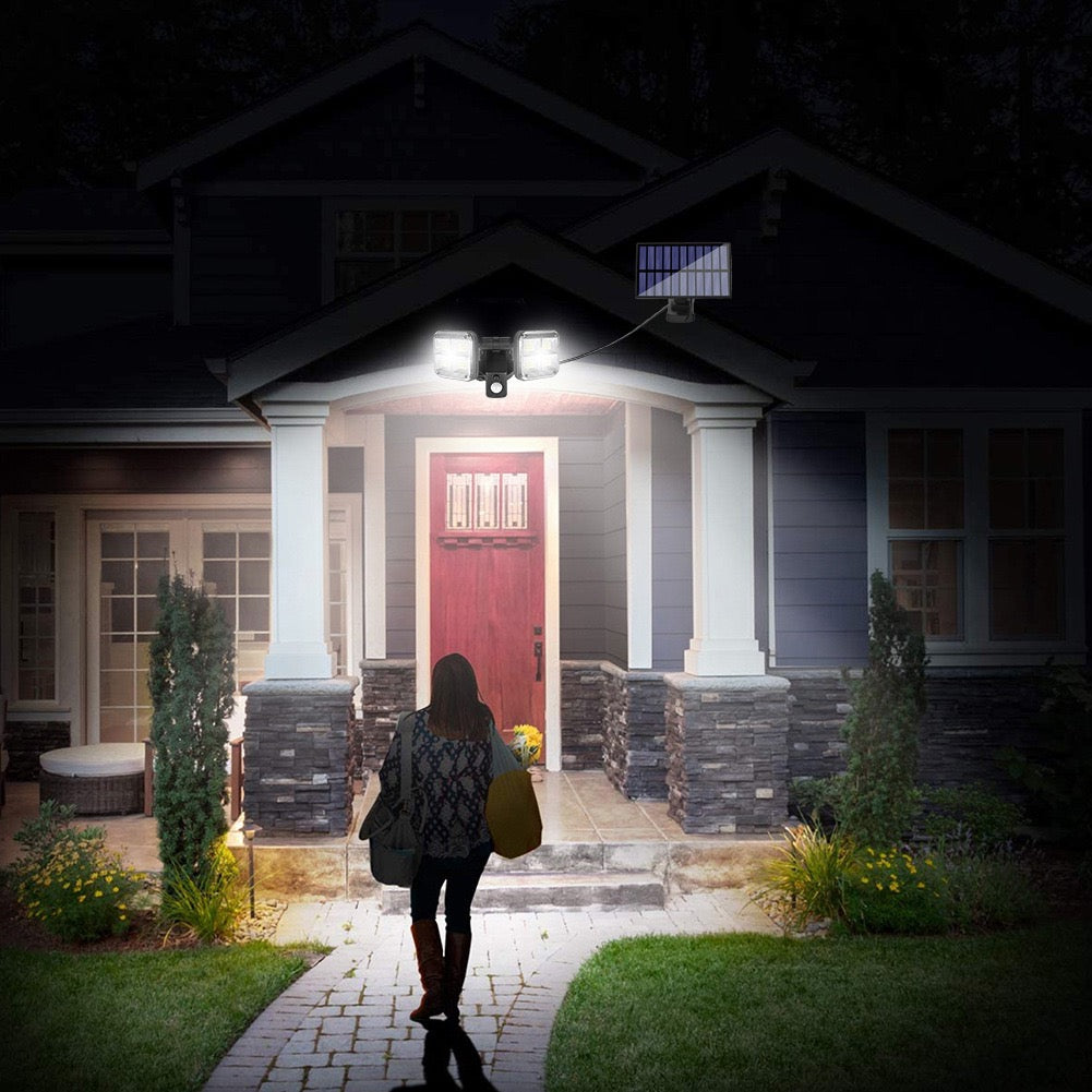 A person walking on a brick path to a house at night with the help of a motion sensor LED solar light