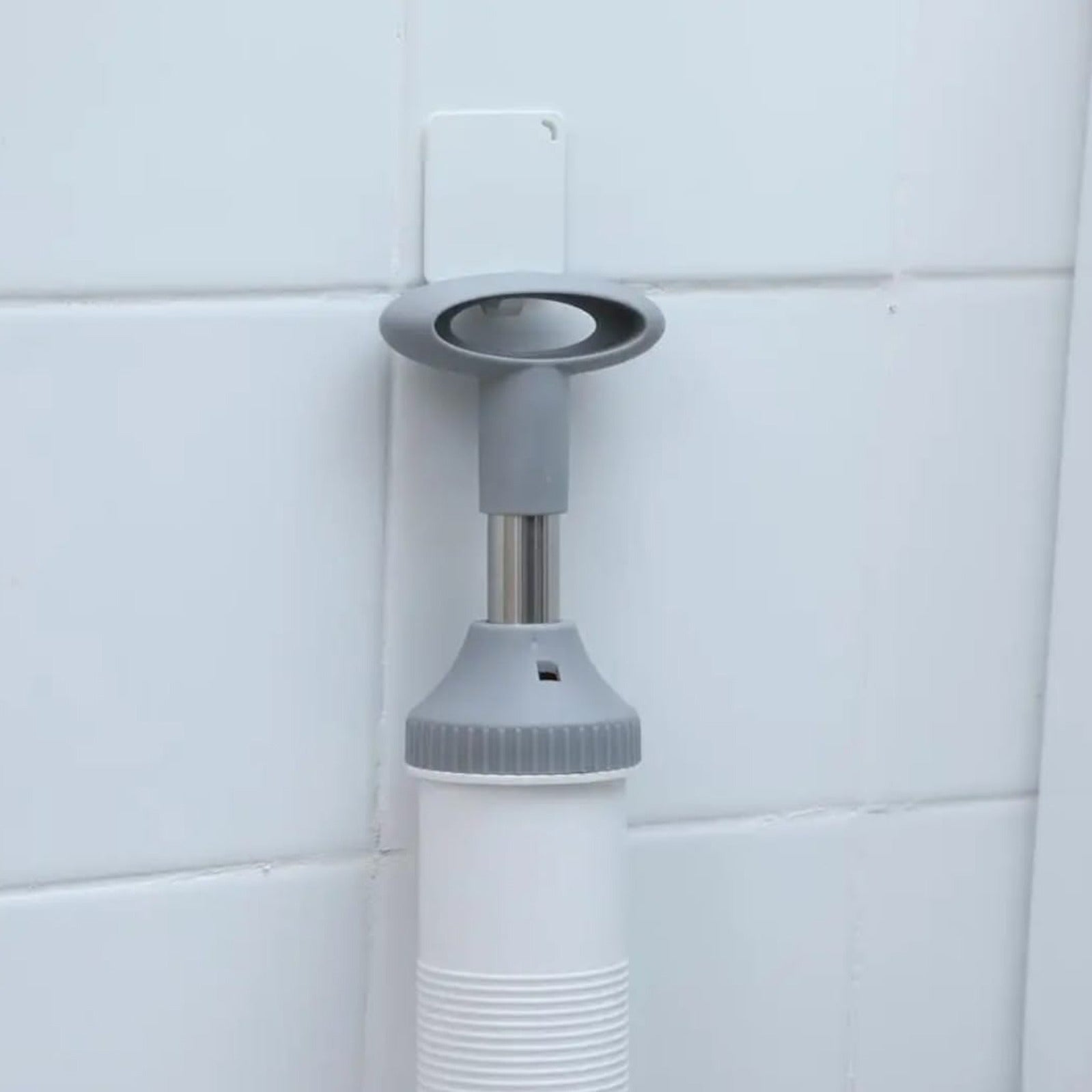 A Vacuum Type Multi-Purpose Pipeline Unclogger is Hanged on the Bathroom Wall.