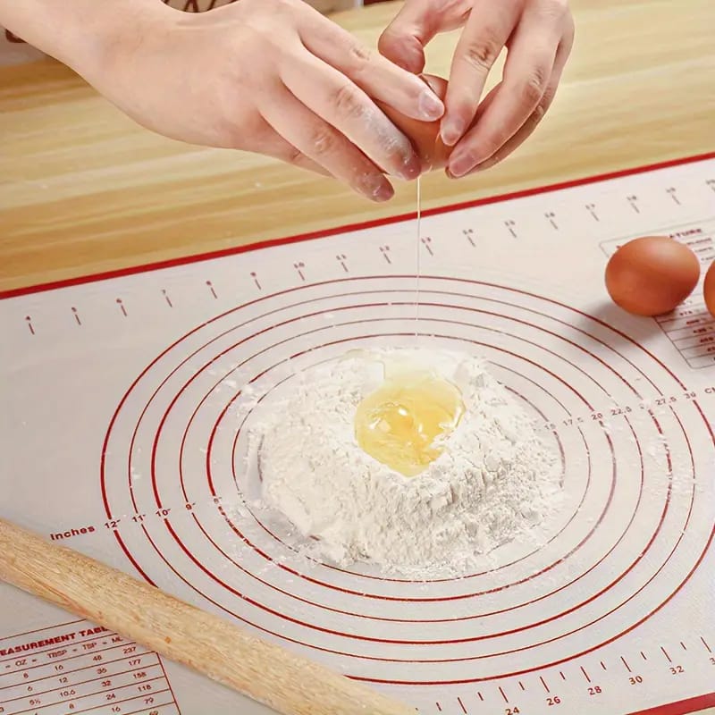 A Person is Making Dough in a Non-Slip Baking Mat With Measurements.