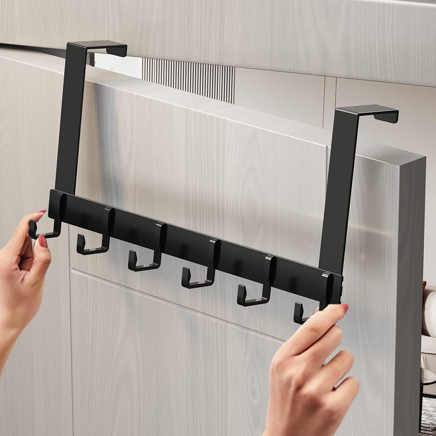 A Person is Fixing Over Door Hooks On the Door.