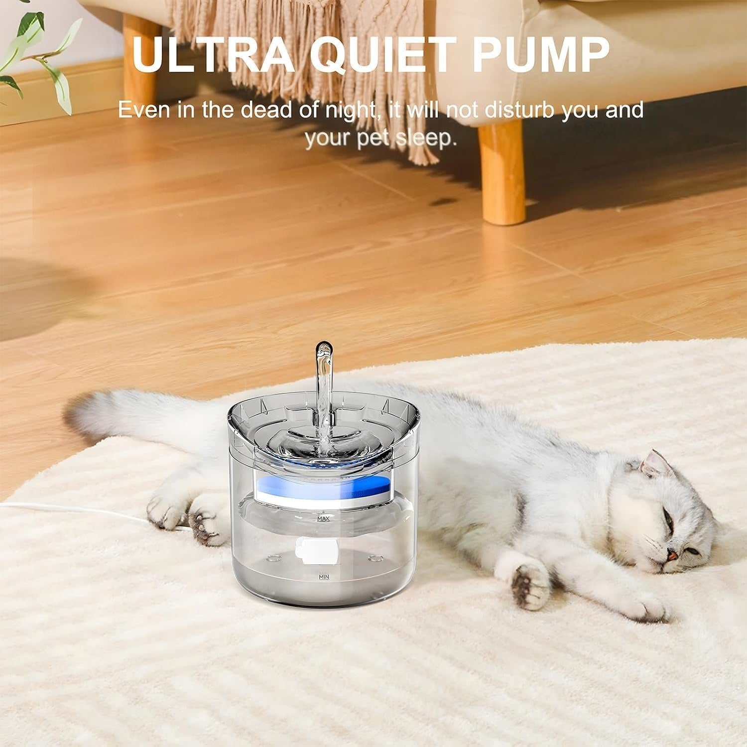 A transparent pet water fountain with a central flowing stream is placed on a soft rug beside a sleeping white cat in a cozy living room setting.
