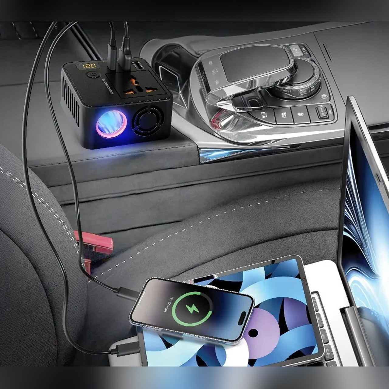 Car dashboard with a smartphone charging pad and multiple devices plugged in on Porodo 200W Car Power Inverter.