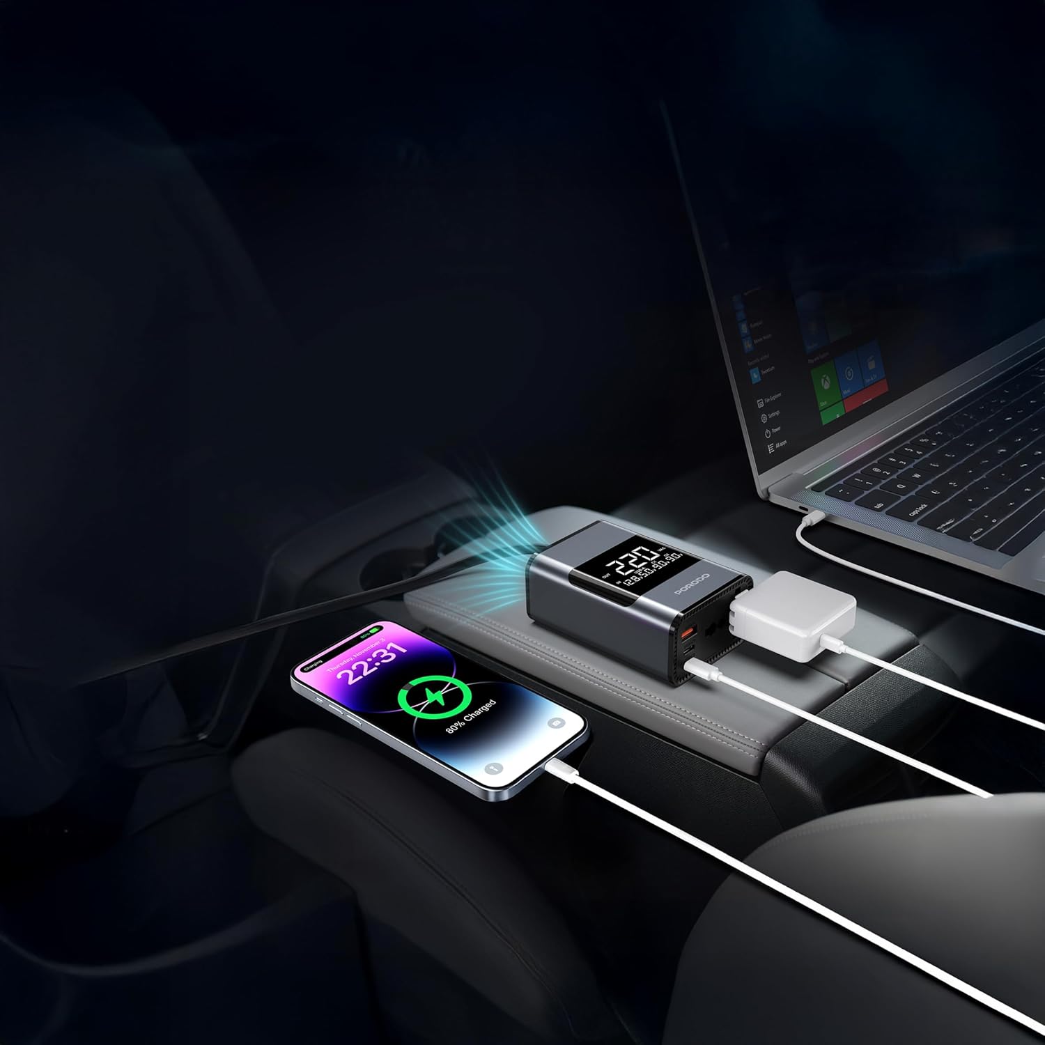 Car dashboard with multiple devices charging, including a laptop and smartphone using Porodo Universal AC Car Power Inverter.