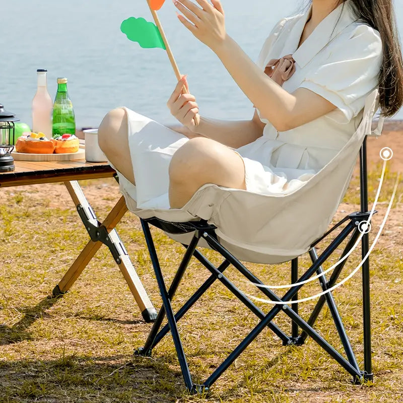 A Woman is Sitting On a Portable Folding Camping Chair.