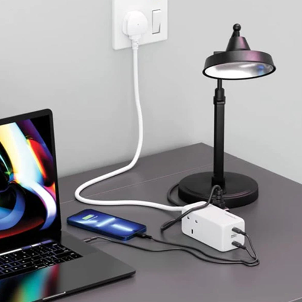 Powerology 65W USB Power Strip with Dual Power Sockets in white color placed on the table next to a laptop and mobile, both conveniently plugged into it for efficient charging